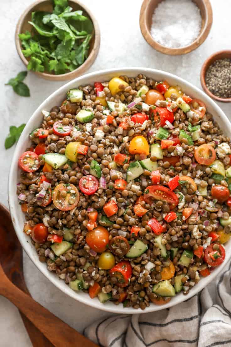 bowl of lentils with tomatoes and cucumbers chopped in.