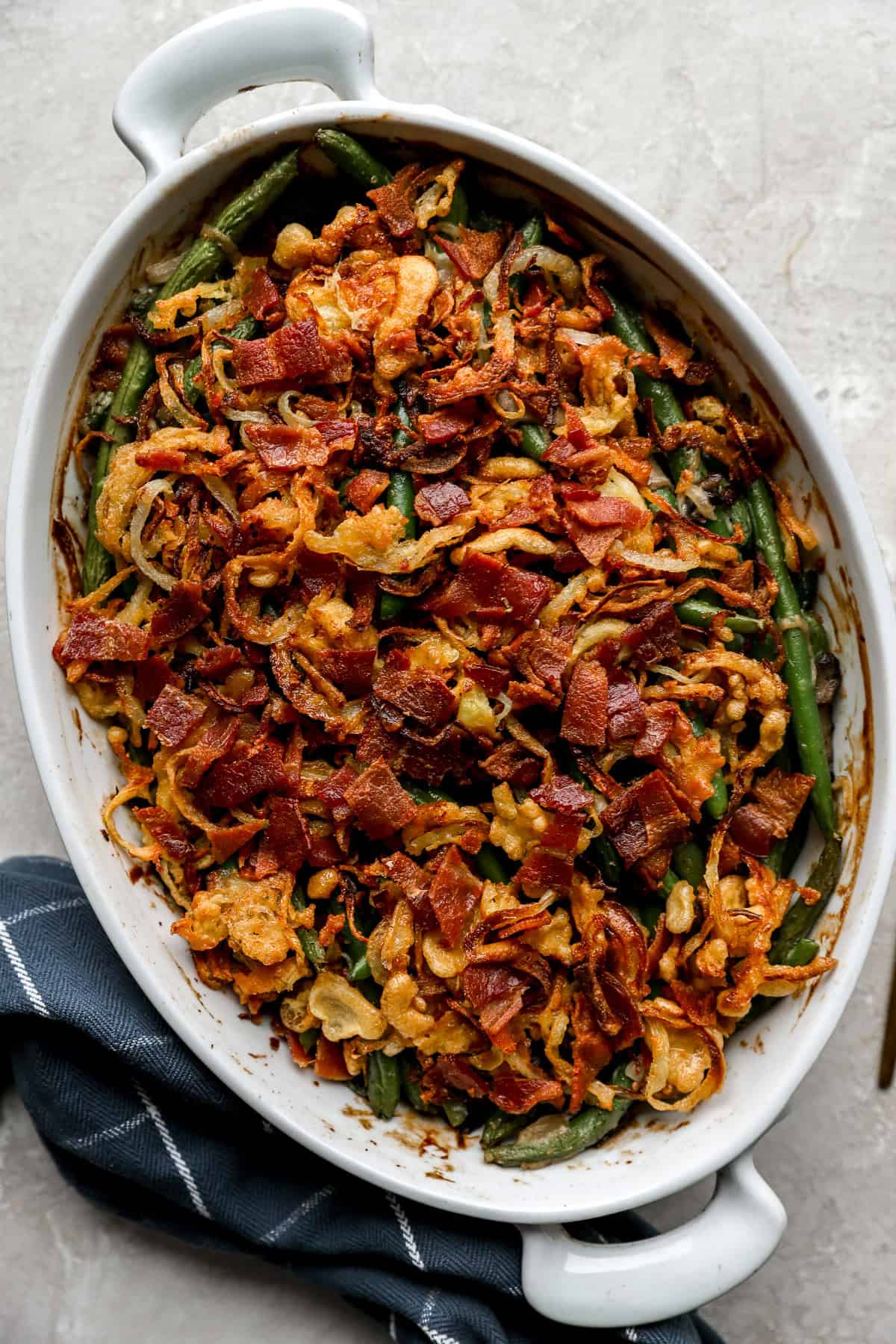 Fully cooked green bean casserole in a white baking dish.