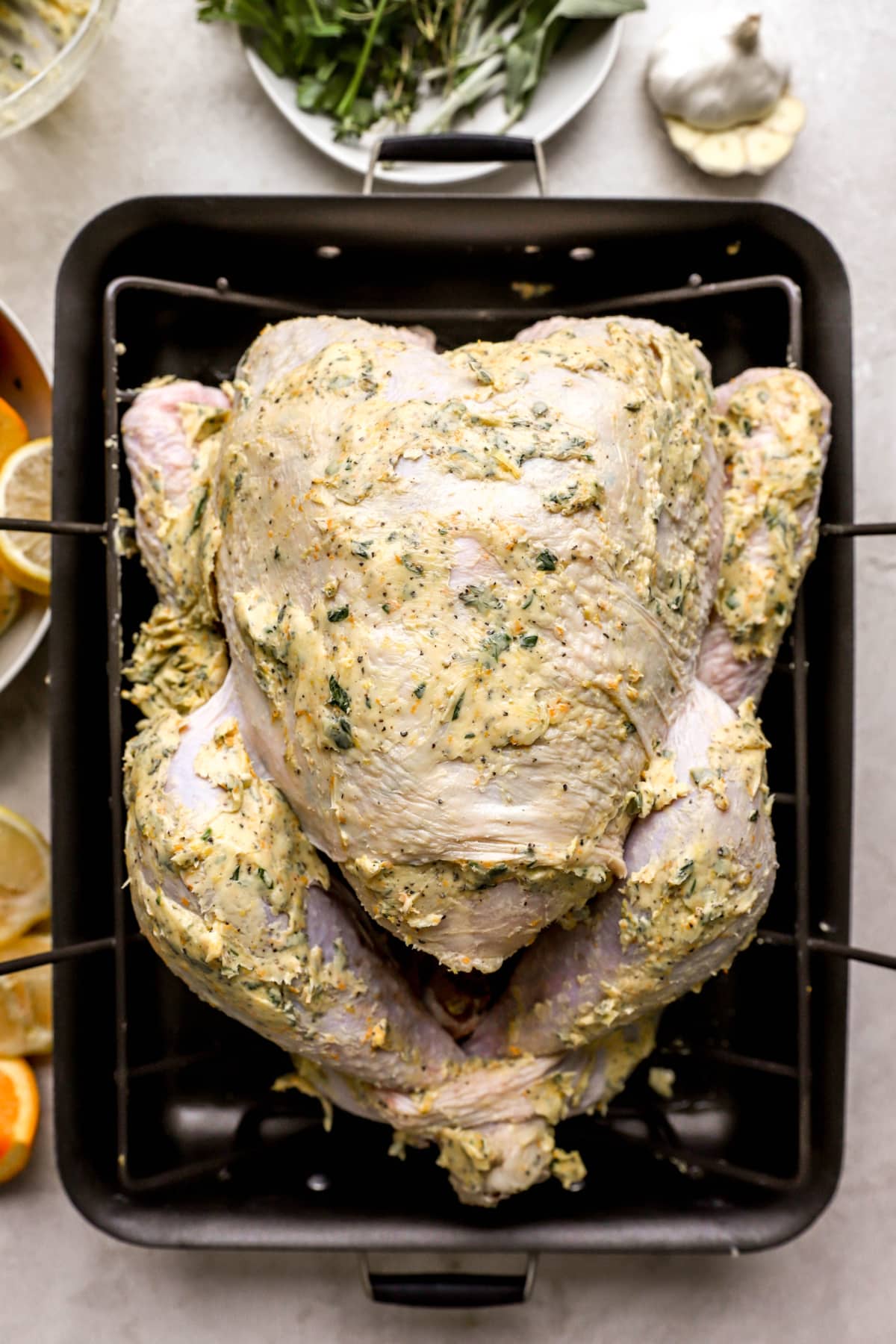overhead of a seasoned, uncooked turkey in a roasting pan.