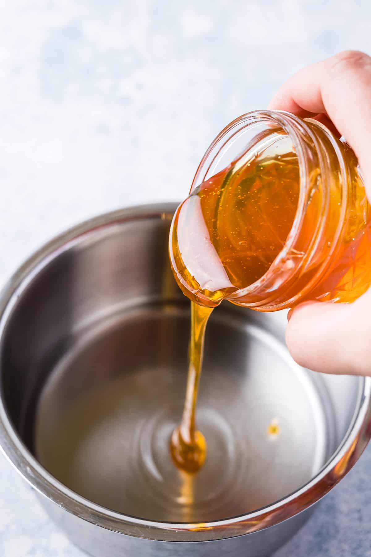 honey pouring into saucepan to make simple syrup recipe