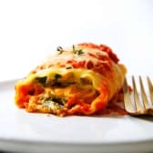 A plate of a pumpkin lasagna roll up ready to eat.