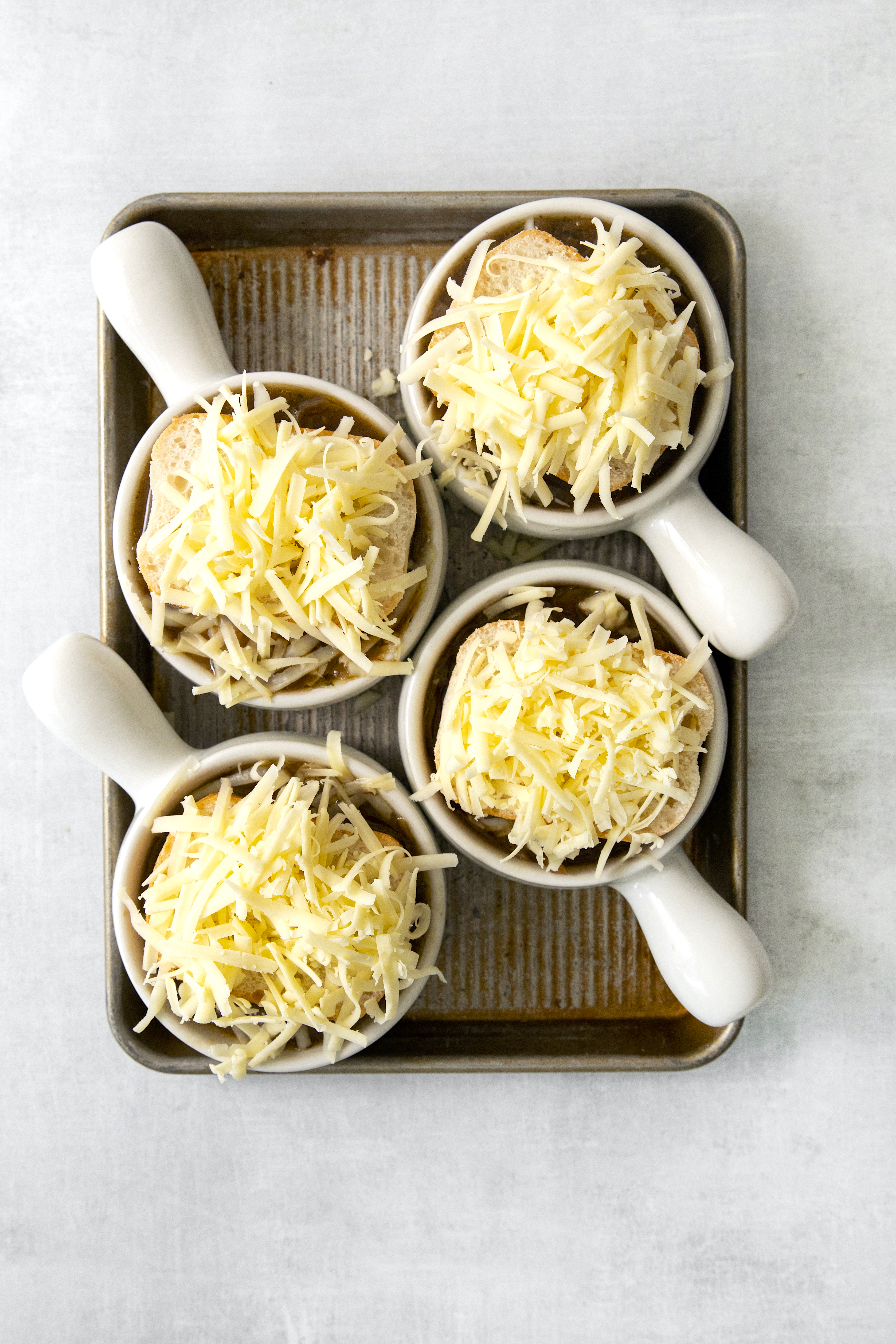 french onion soup in bowls topped with bread and cheese.
