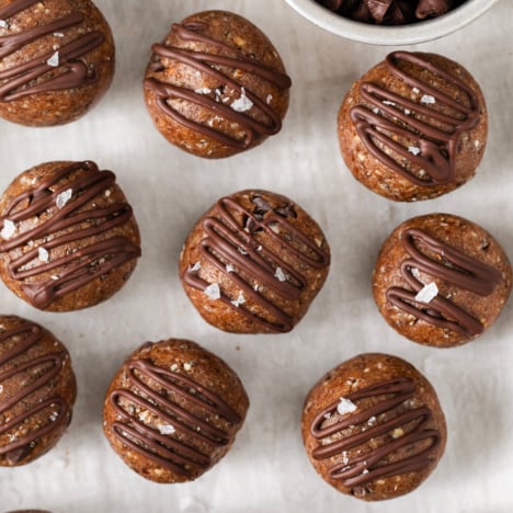 closeup of chocolate chip cookie energy balls drizzled with chocolate.