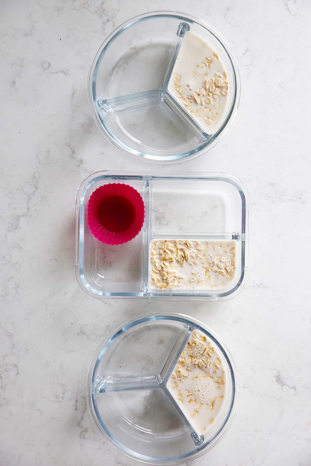 three containers with oats in milk.