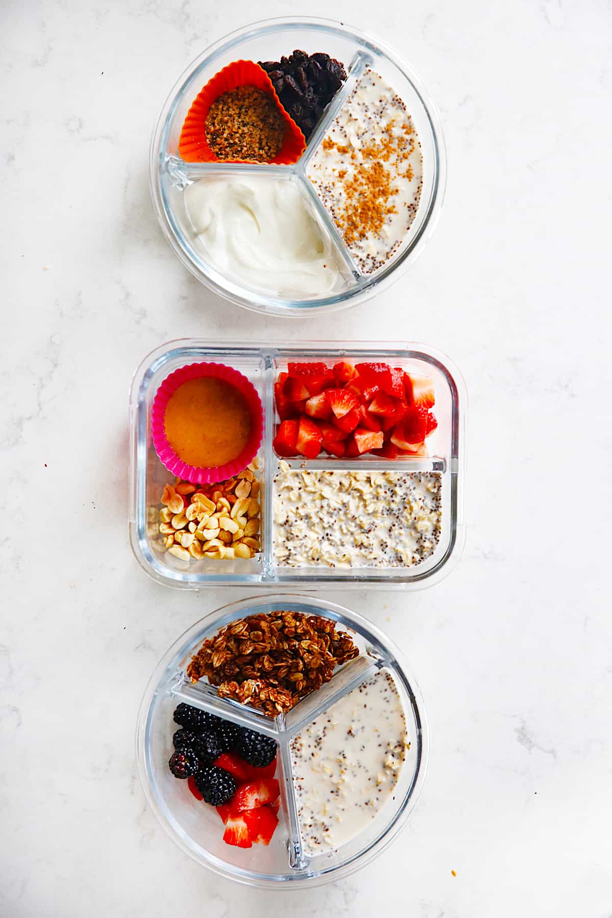 overhead of three meal prep containers with different variations of oatmeal.