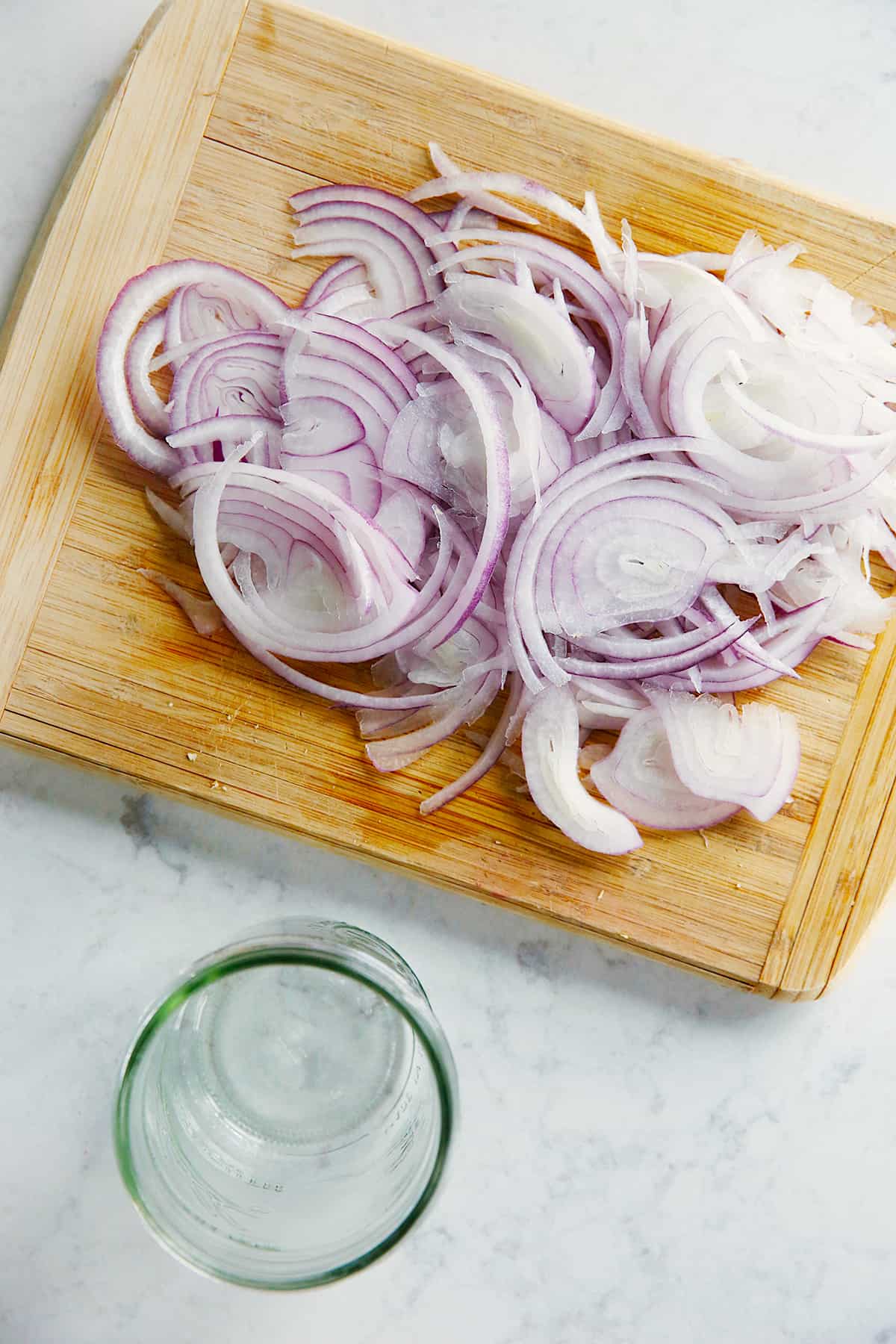 sliced red onions on a cutting board from above.