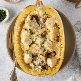 overhead of a spaghetti squash halved and filled with alfredo.