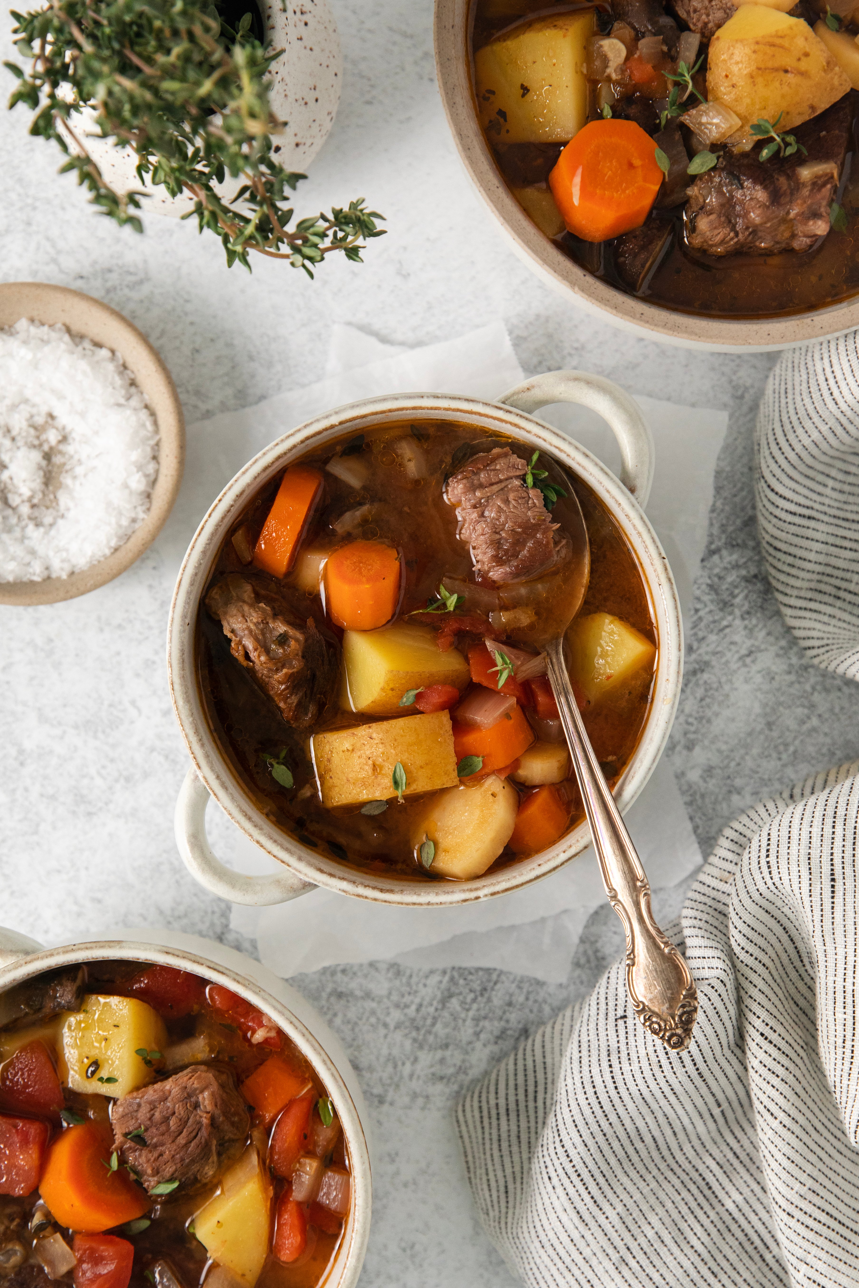 overhead of three bowls filled with crock pot beef stew.