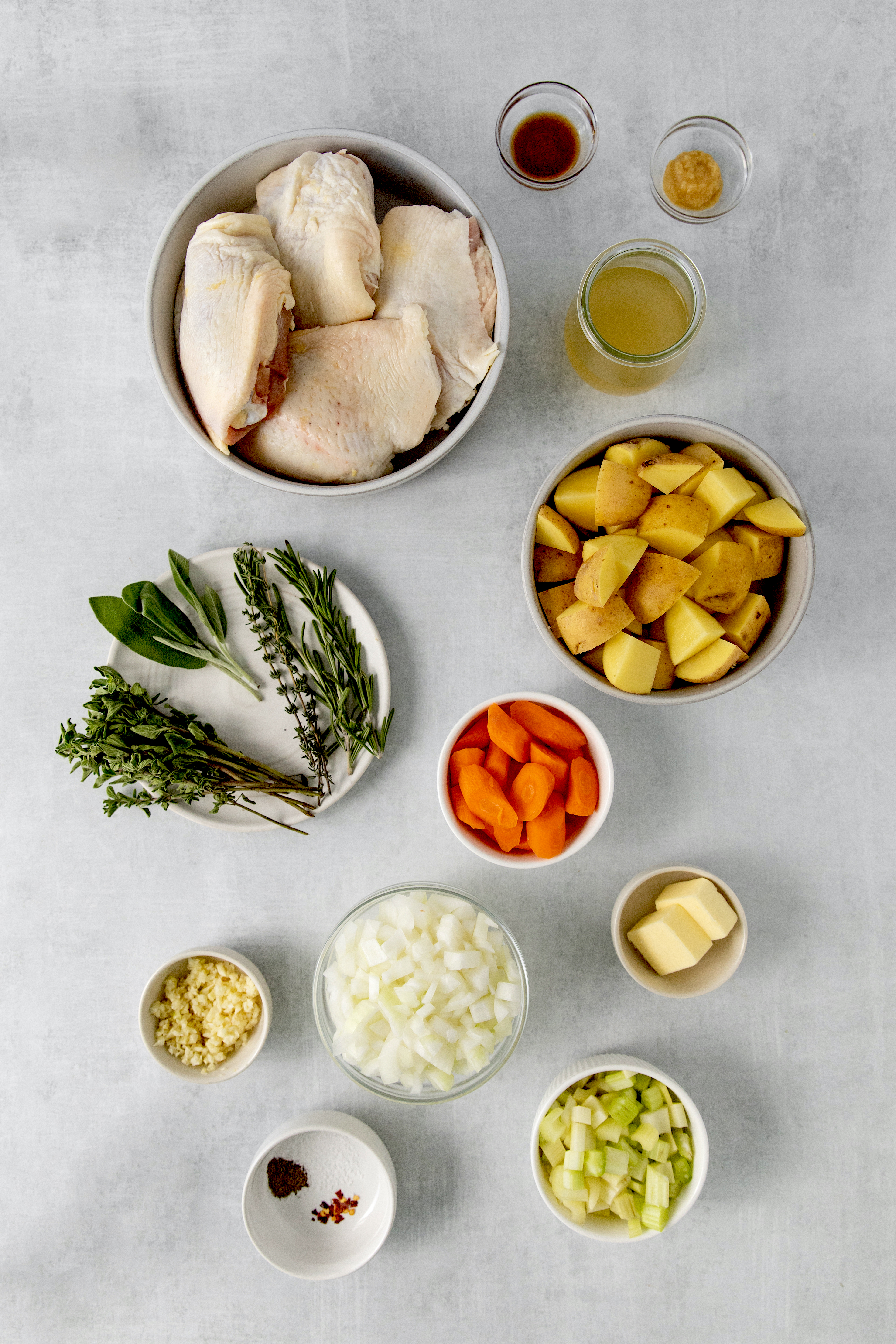 overhead of slow cooker chicken and veggie dinner ingredients in bowls.