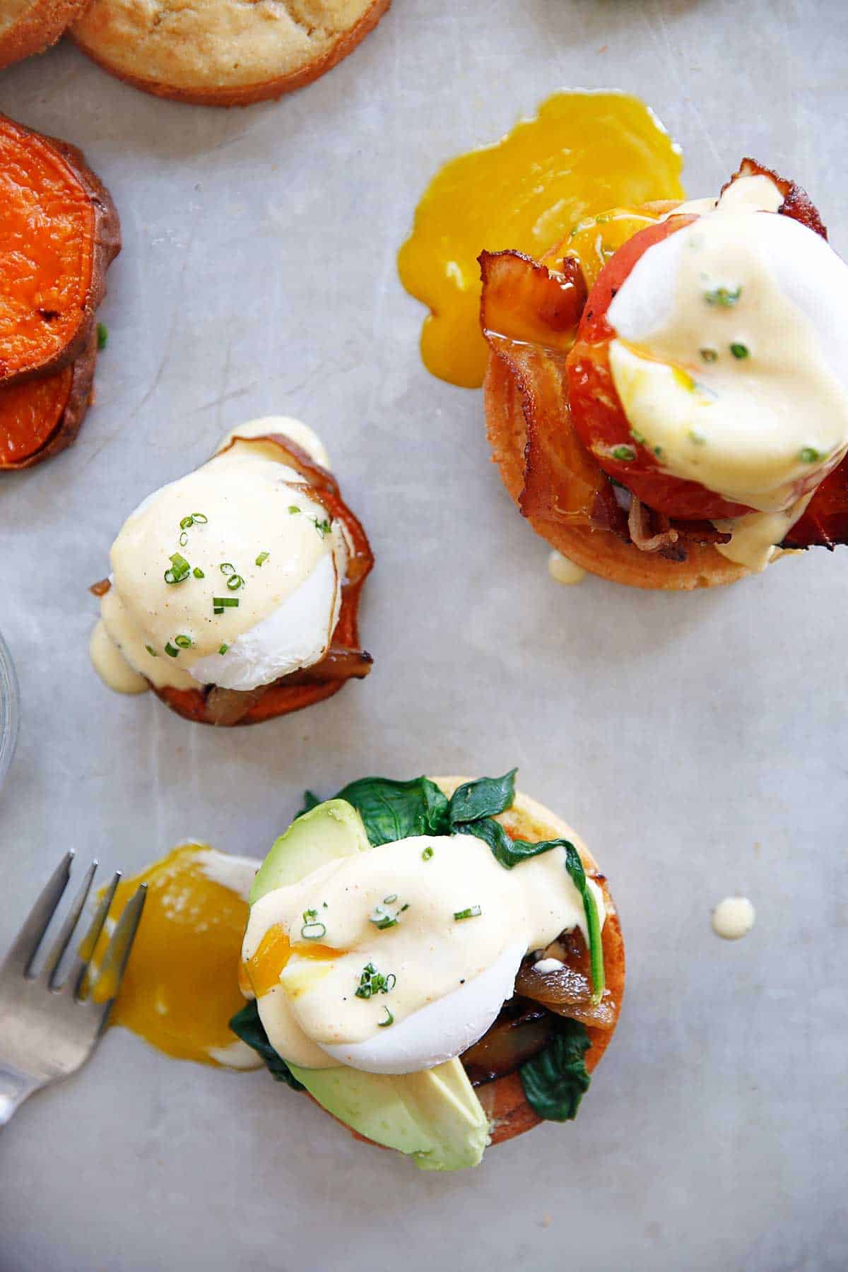 Overhead of three egg sandwiches with poached eggs.