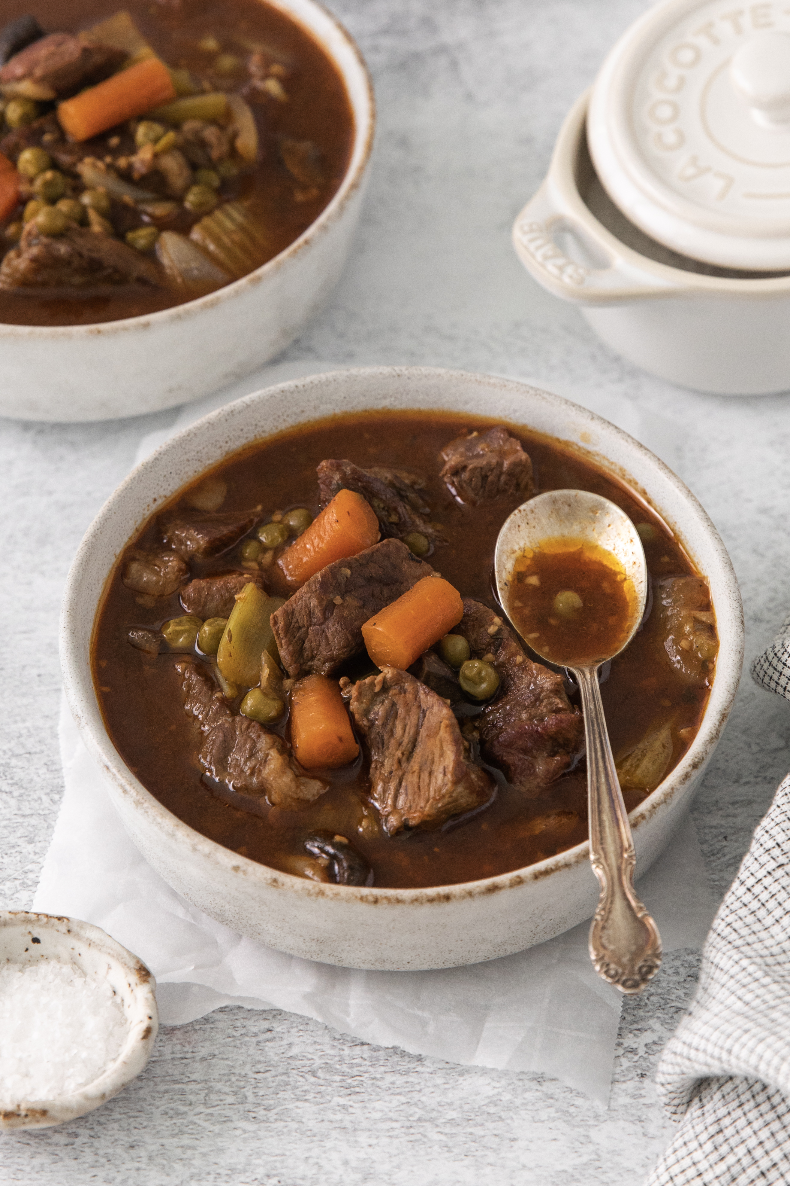 a bowl of beef stew with a spoon on top.