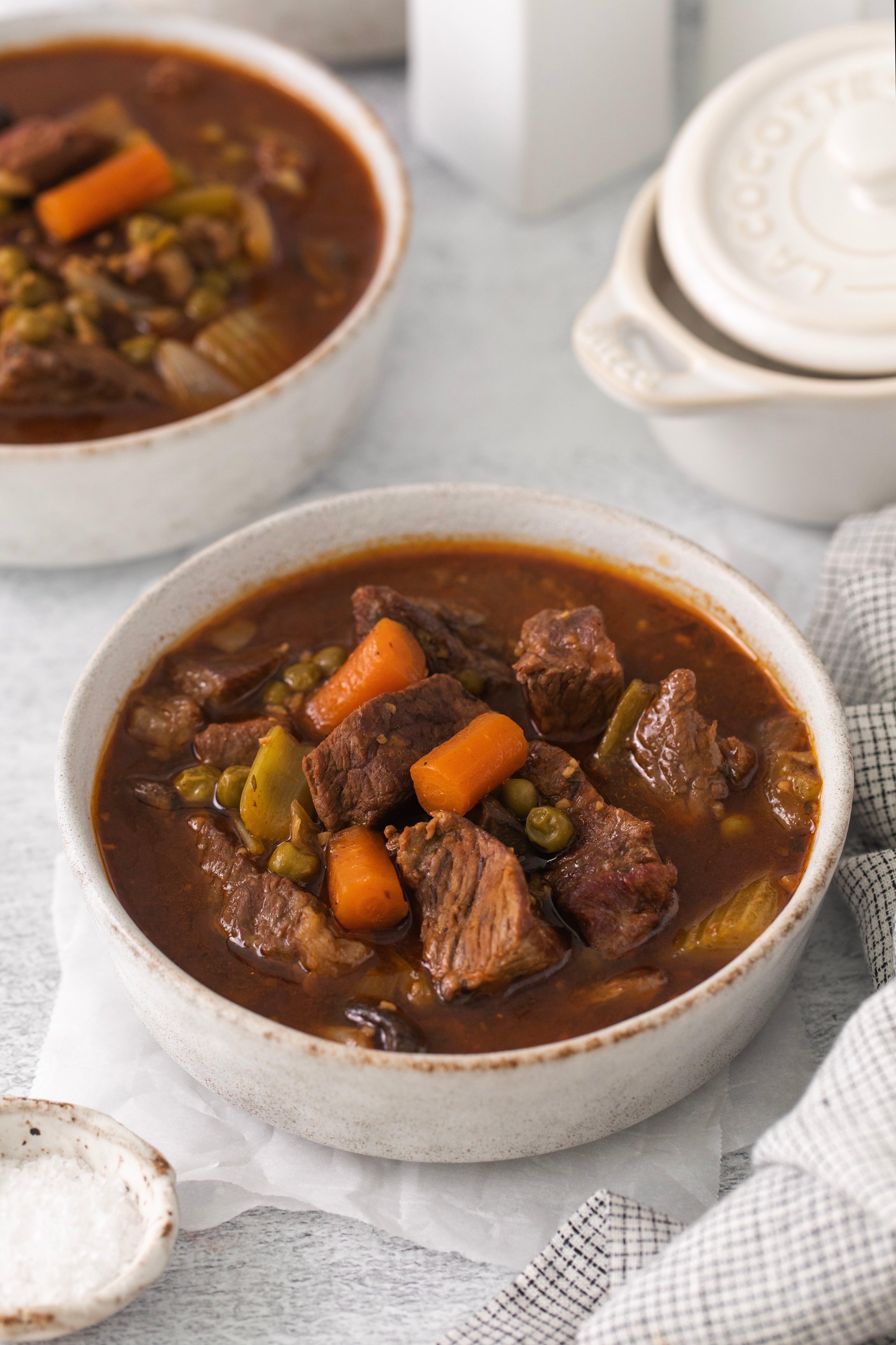 side view of two bowls of crockpot beef stew with one in the forefront.