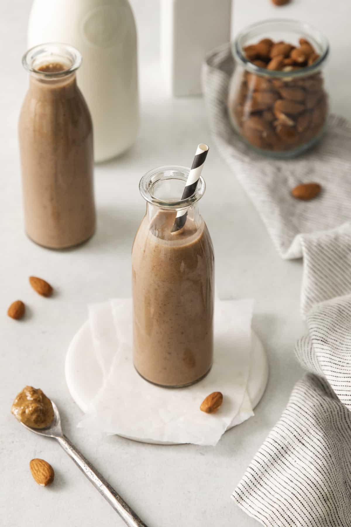 overhead of a jar filled with a protein smoothie with a black and white striped straw.