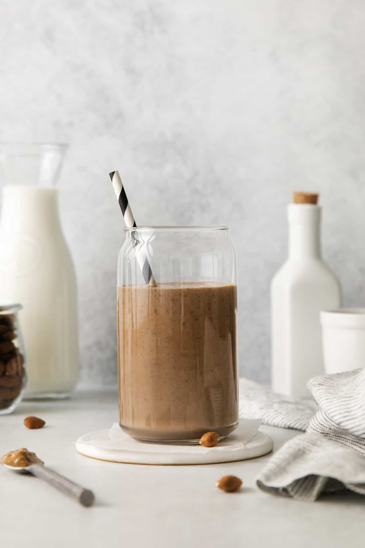 chocolate banana smoothie in a cup with a straw from the side.