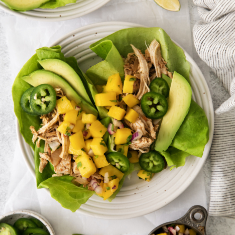 overhead of lettuce wraps with caribbean shredded chicken and mango salsa.