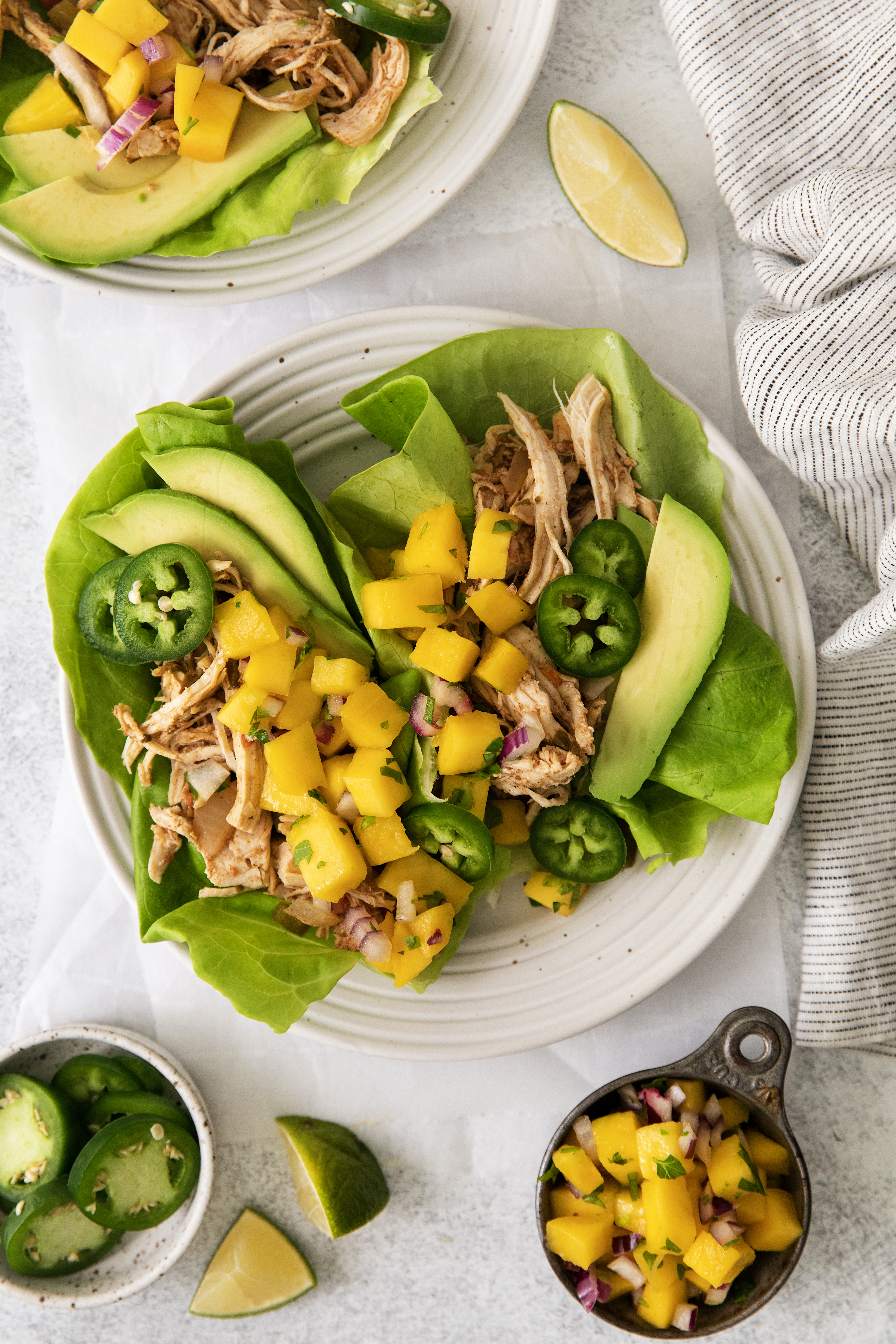 overhead of lettuce wraps with caribbean shredded chicken and mango salsa.