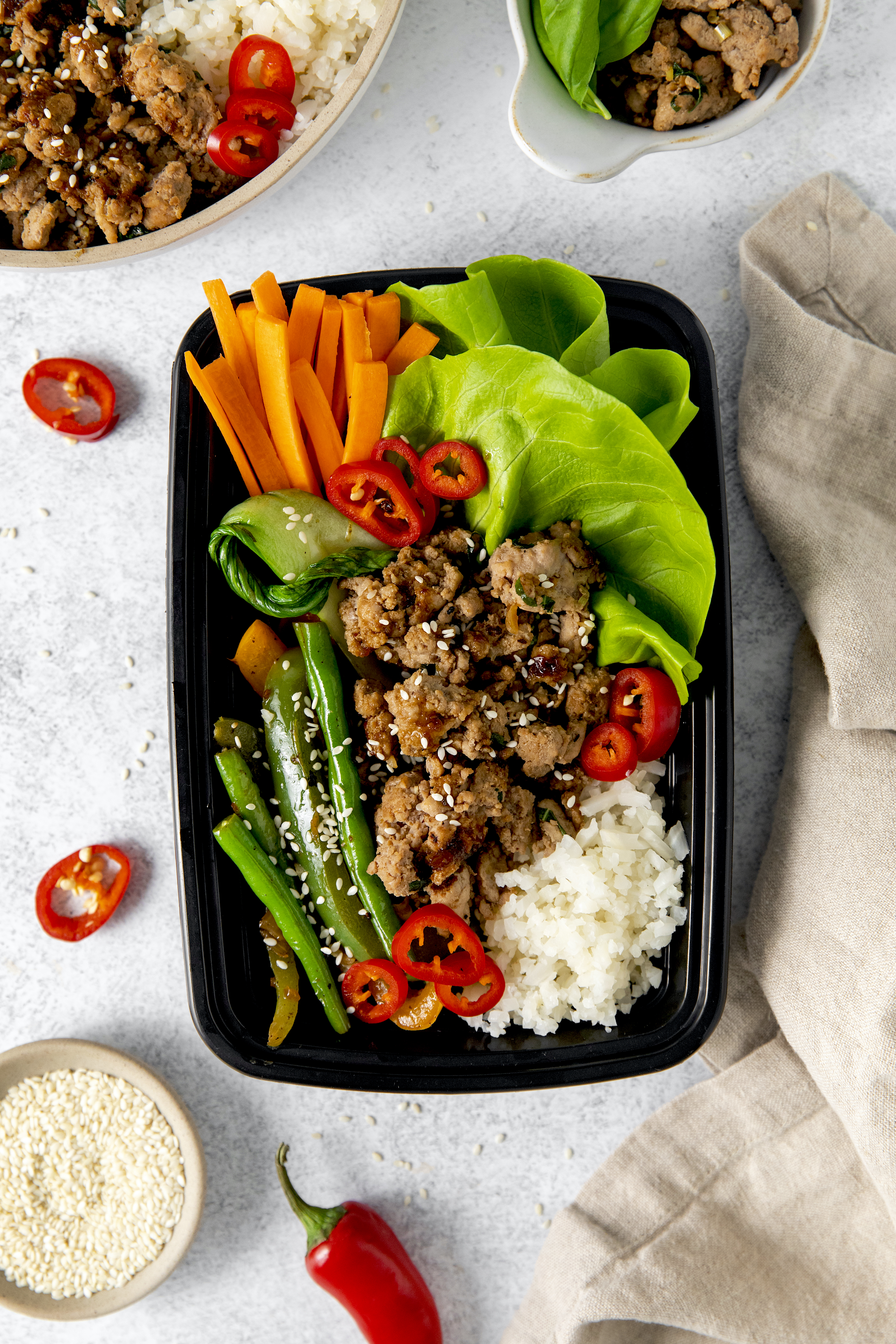 overhead of a to-go container loaded with rice, ground turkey, and veggies.