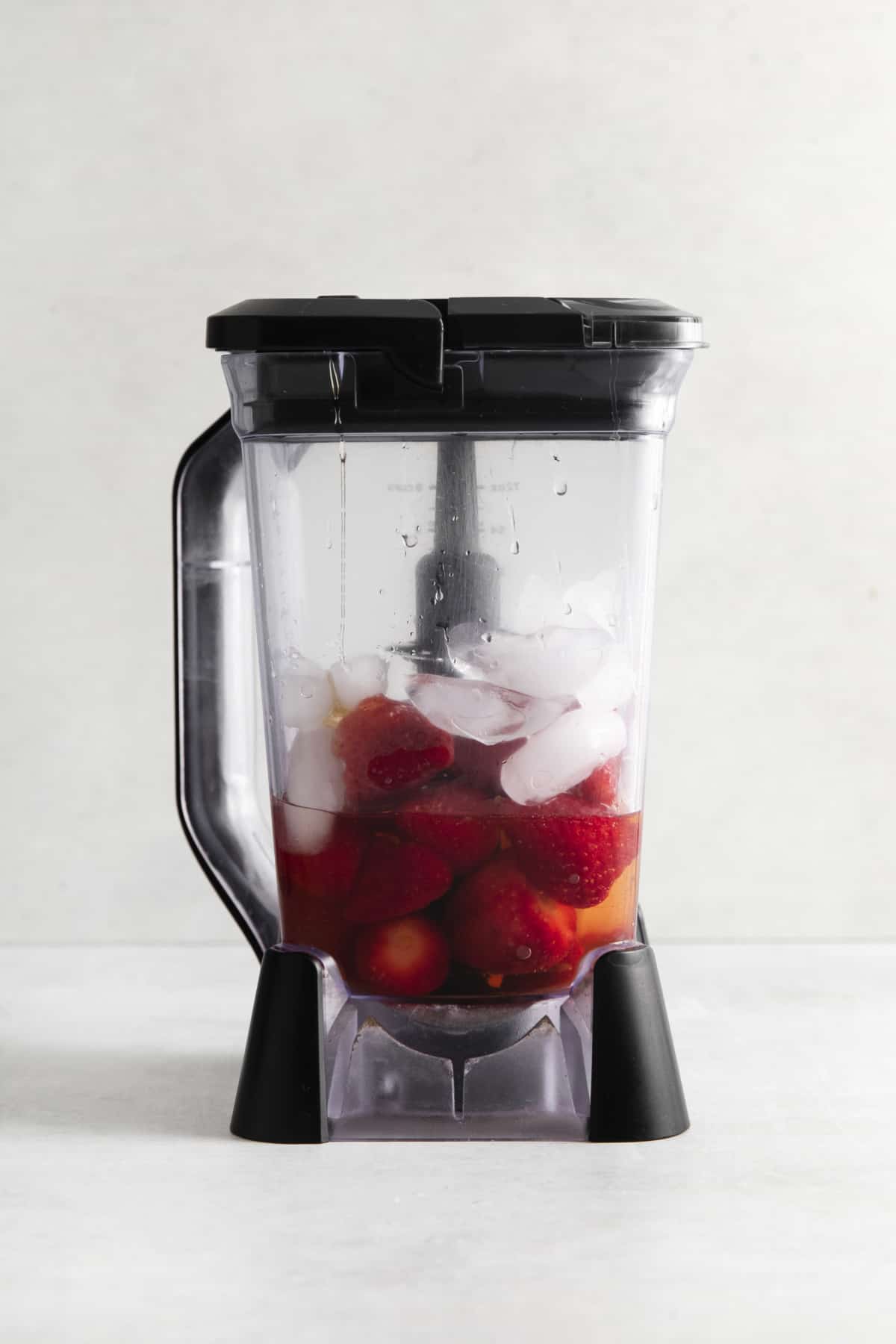 Put strawberries and ice in a blender.