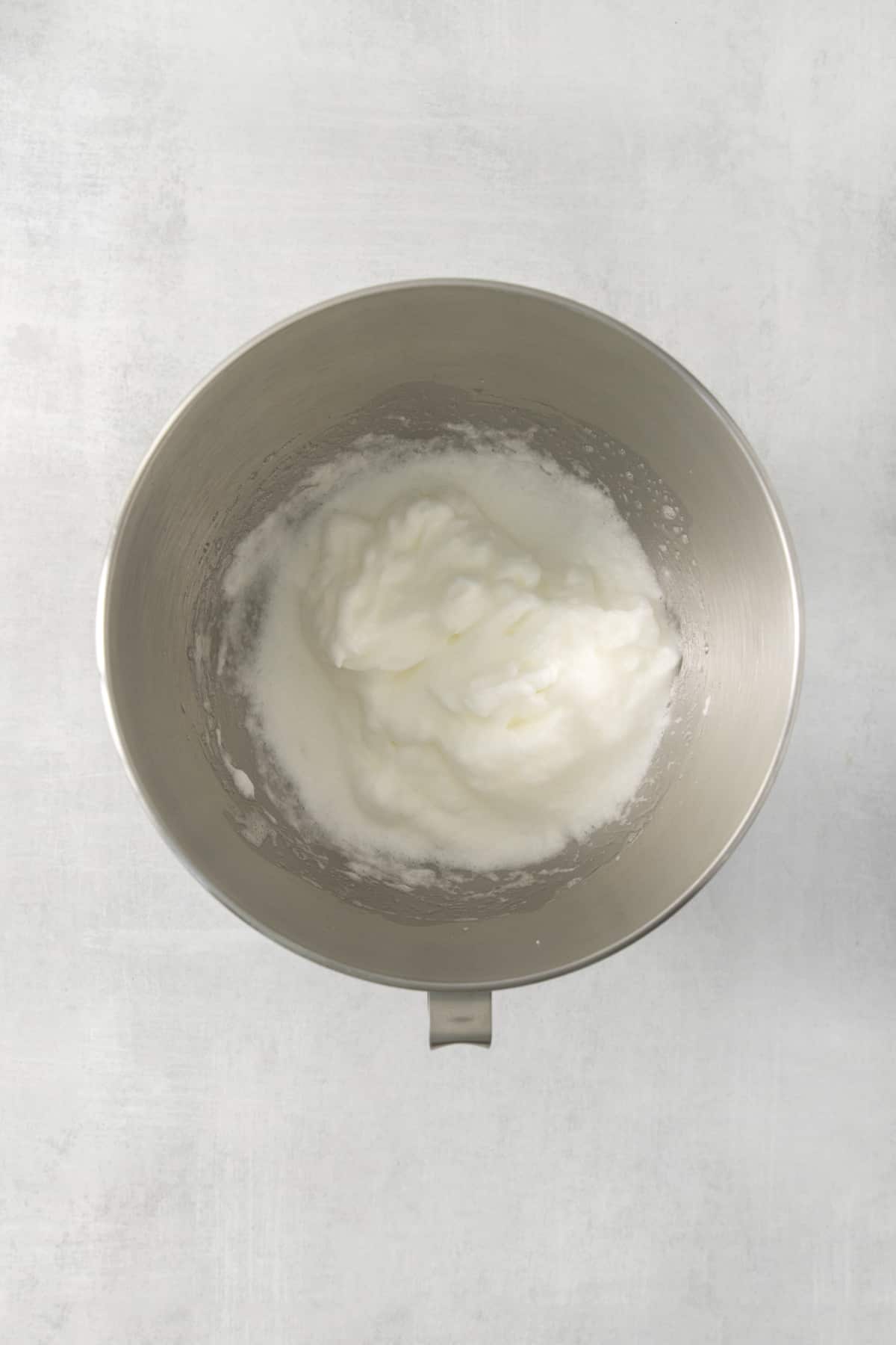 egg whites whipped in a mixing bowl from above.
