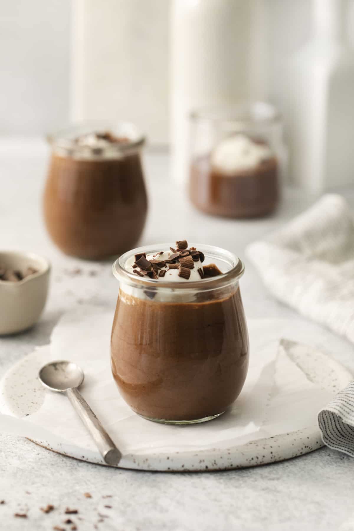 side view of a jar of classic chocolate mousse with others in the background. 