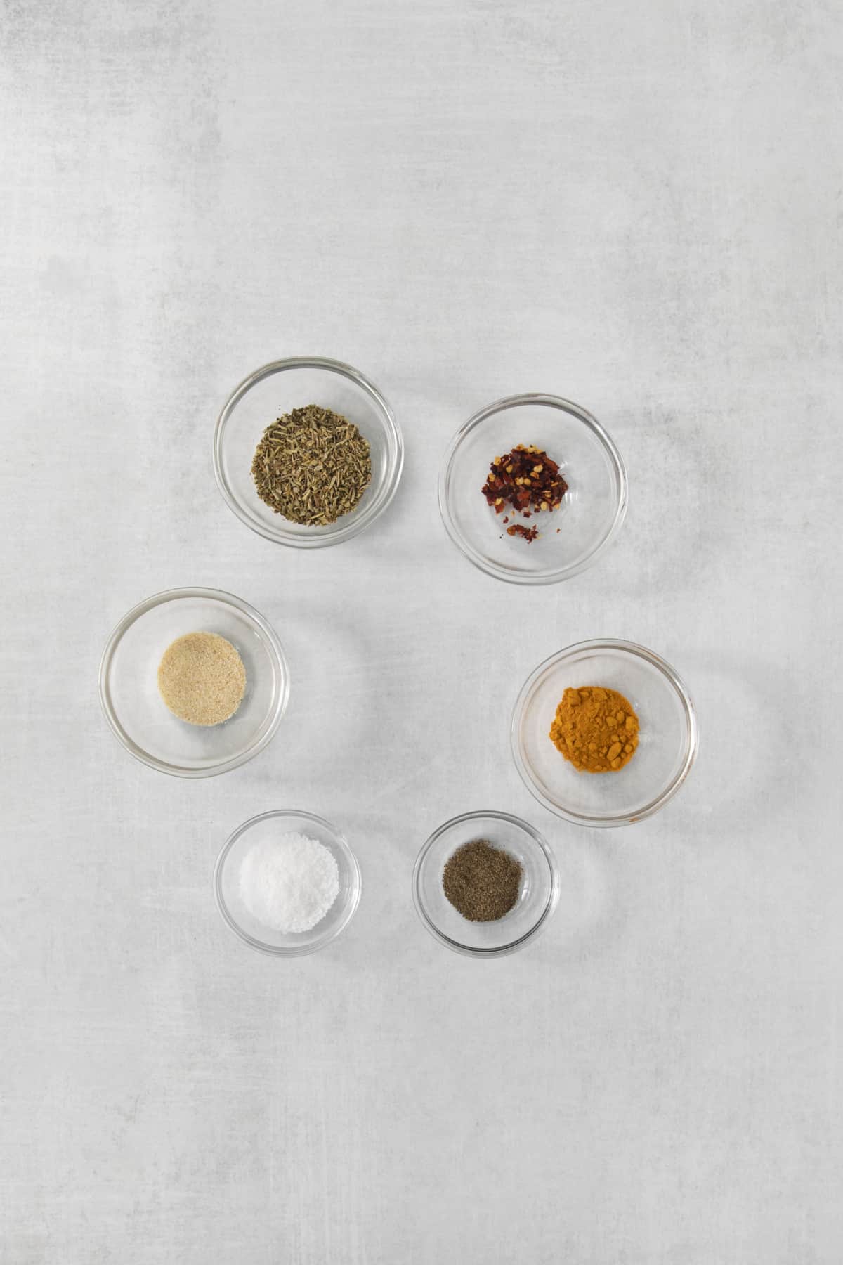 Overhead of different bowls of seasoning rubbed with spices.