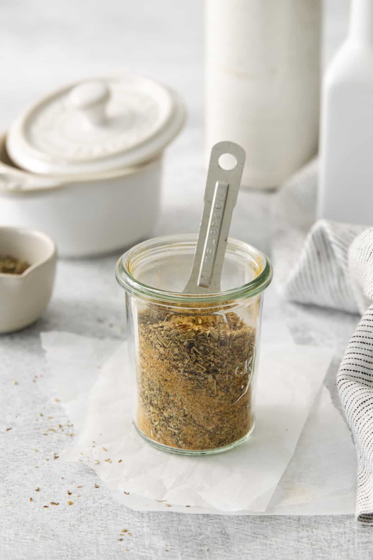 closeup of a jar of chicken rub with a measuring spoon.