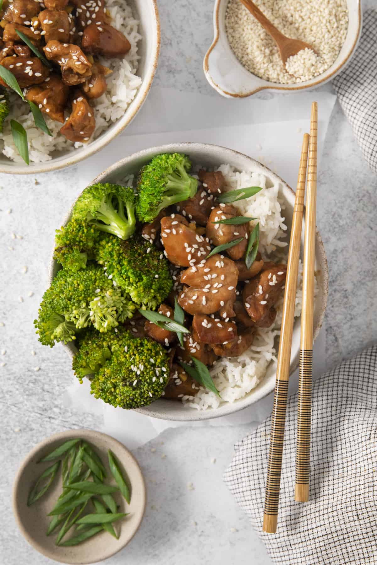 above shot of a bowl of crockpot teriyaki chicken with two chopsticks on top.