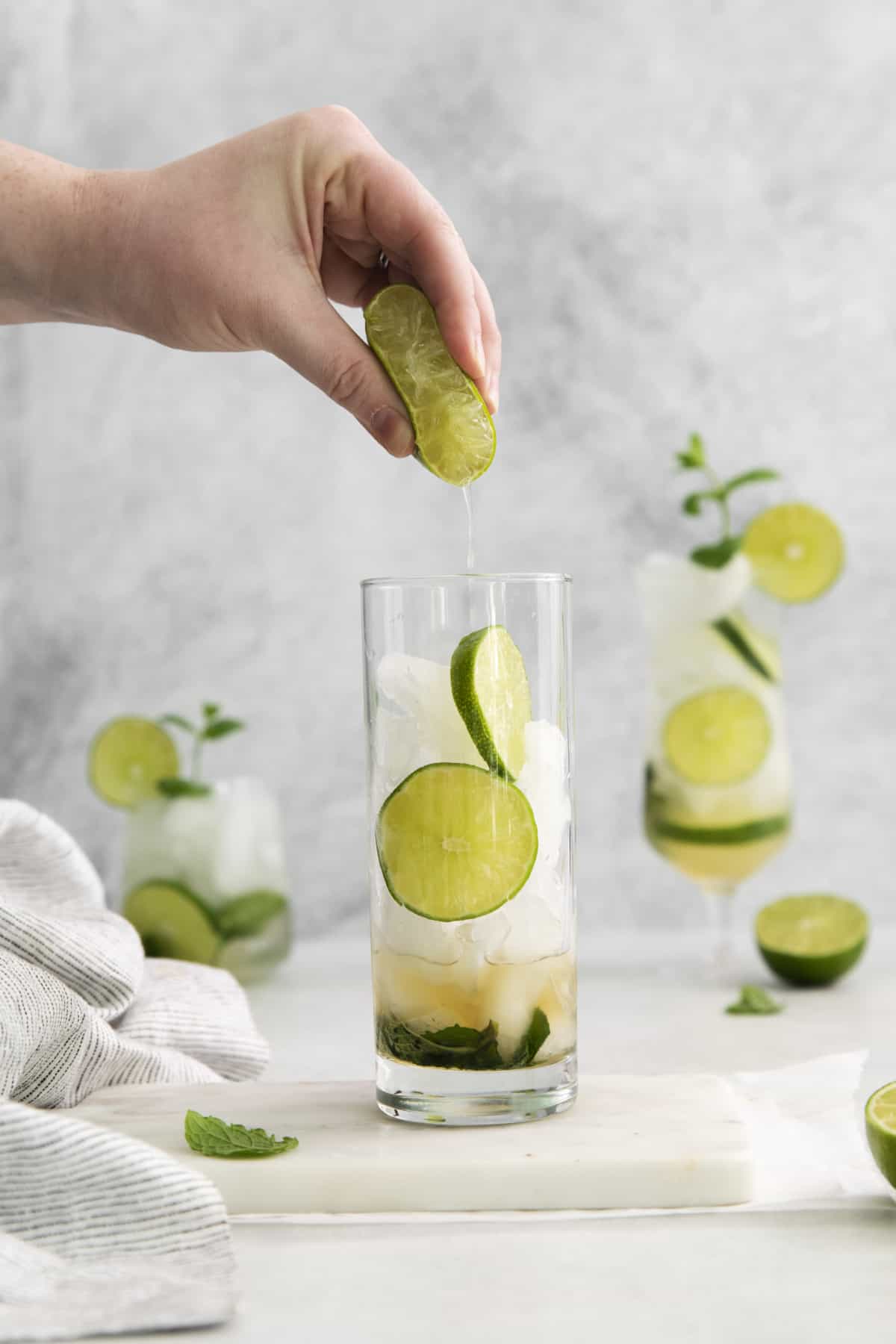 lime juice being squeezed into a cup.