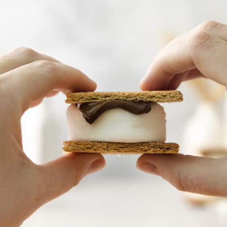 an air fryer s'more being held with two hands.
