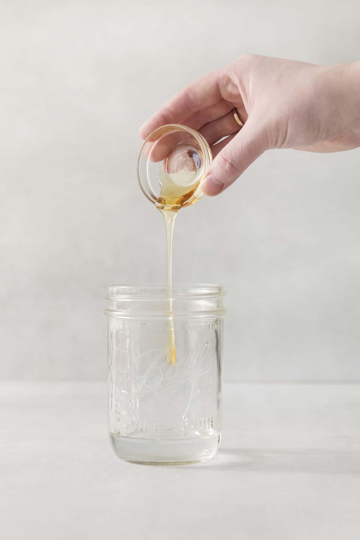 honey being added to a vodka cocktail.