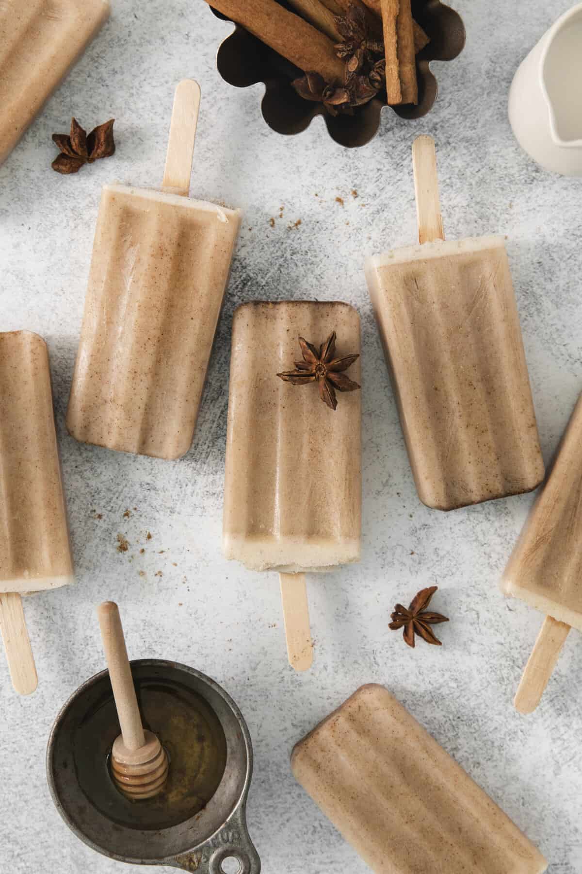 5 chai popsicles lined up on a counter.