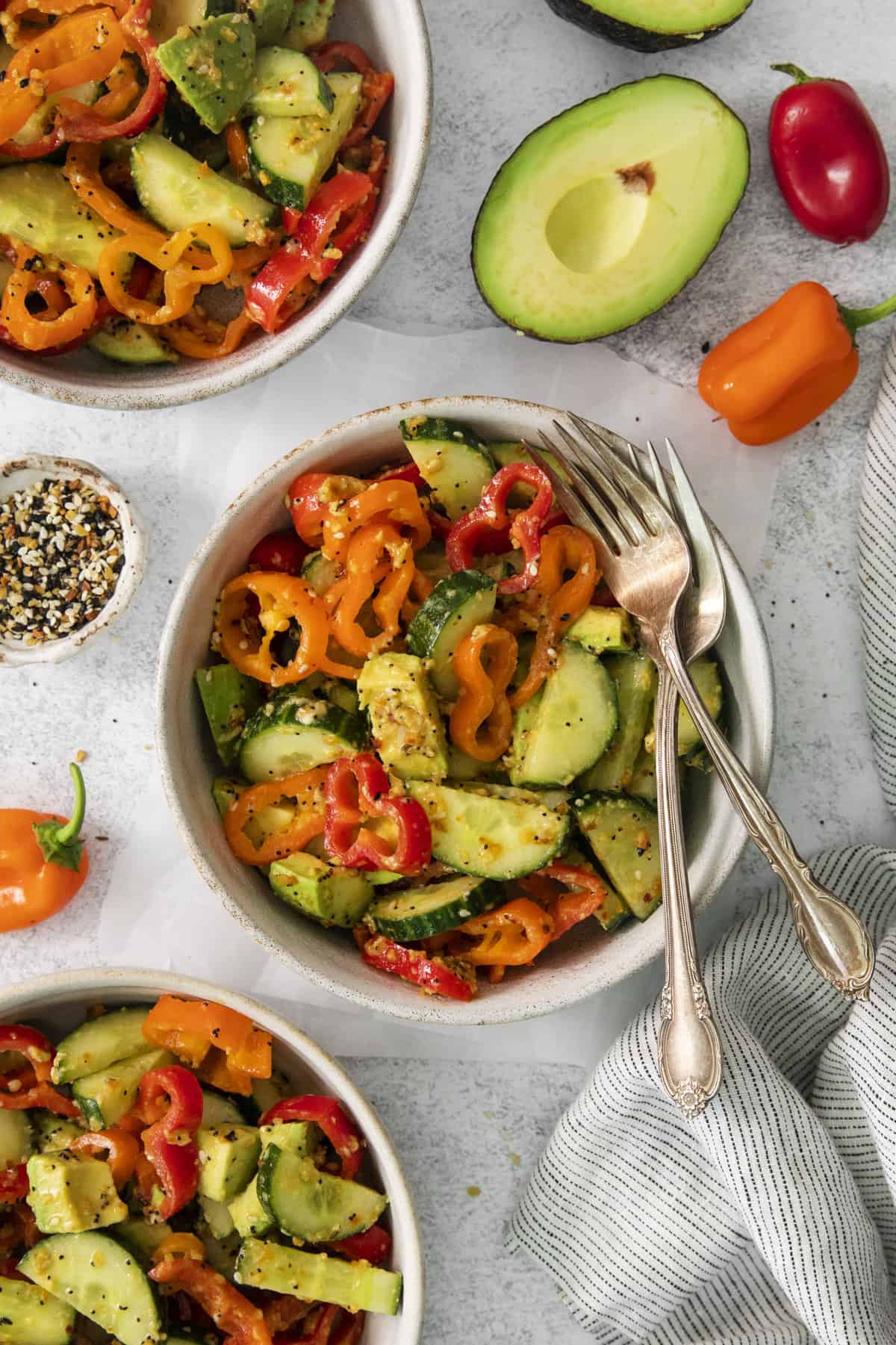 overhead of a bowl with cucumber salad with two forks set on top.