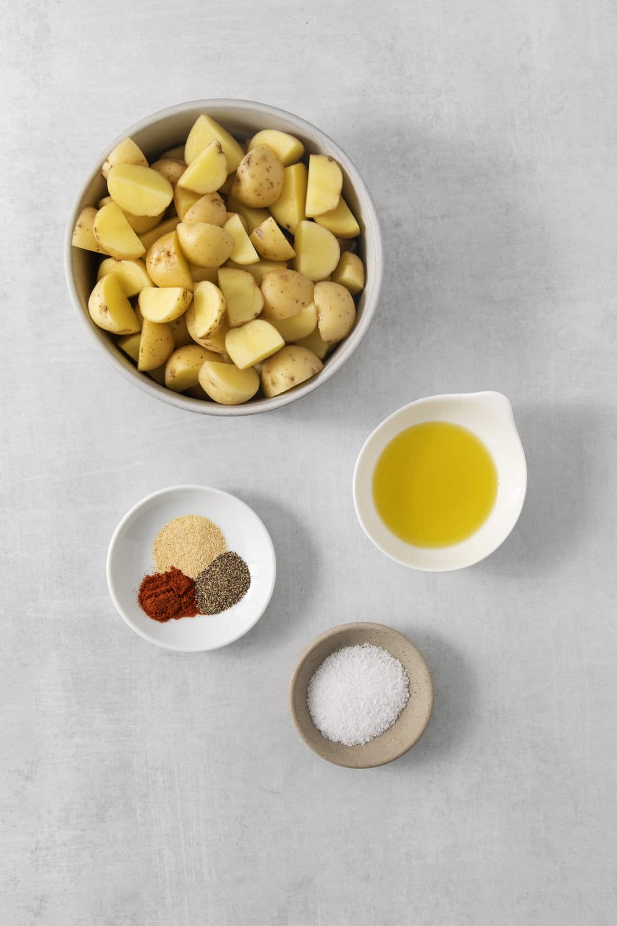 air fryer roasted potato ingredients in separate dishes on a counter.