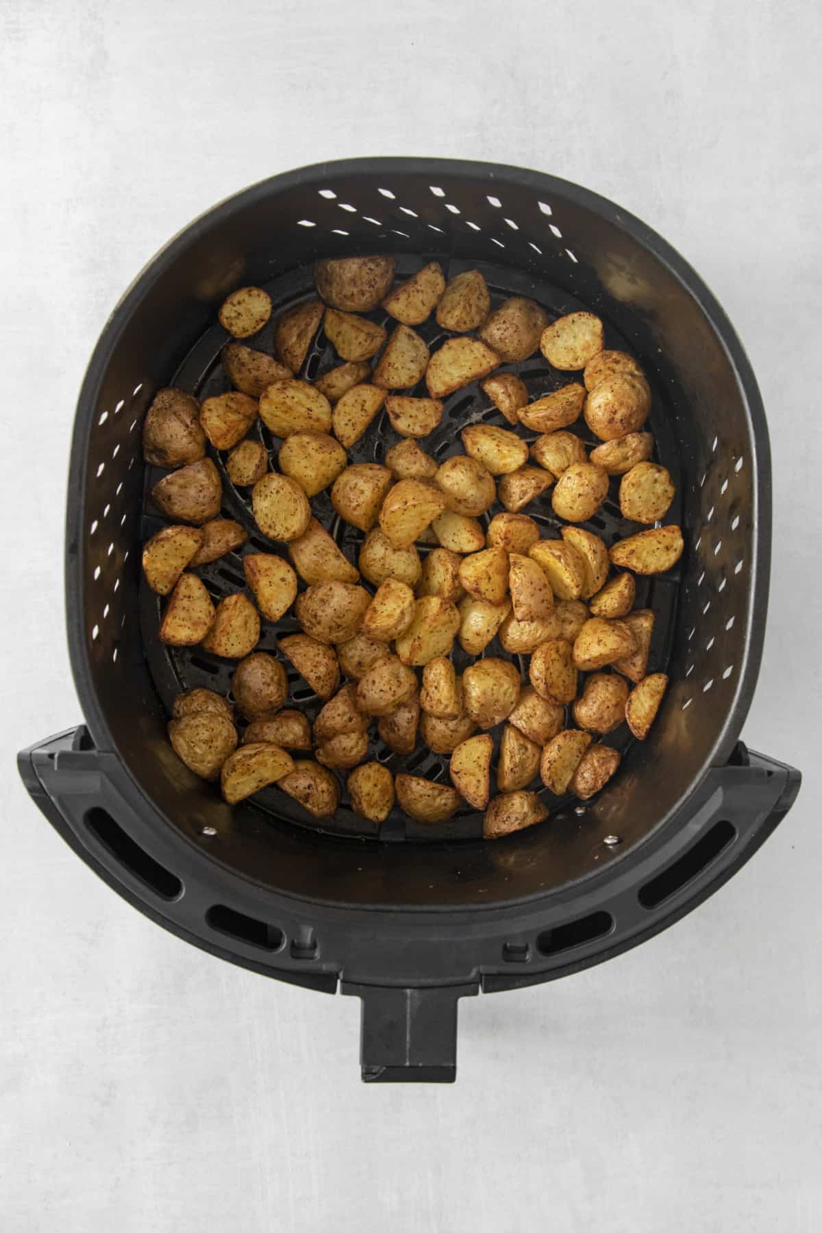 roasted potatoes in the air fryer basket.