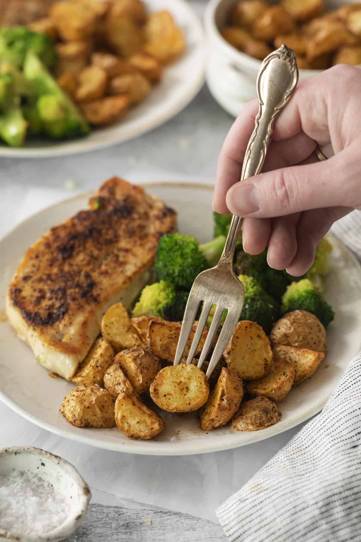 air fryer roasted potatoes on a plate with broccoli and meat.