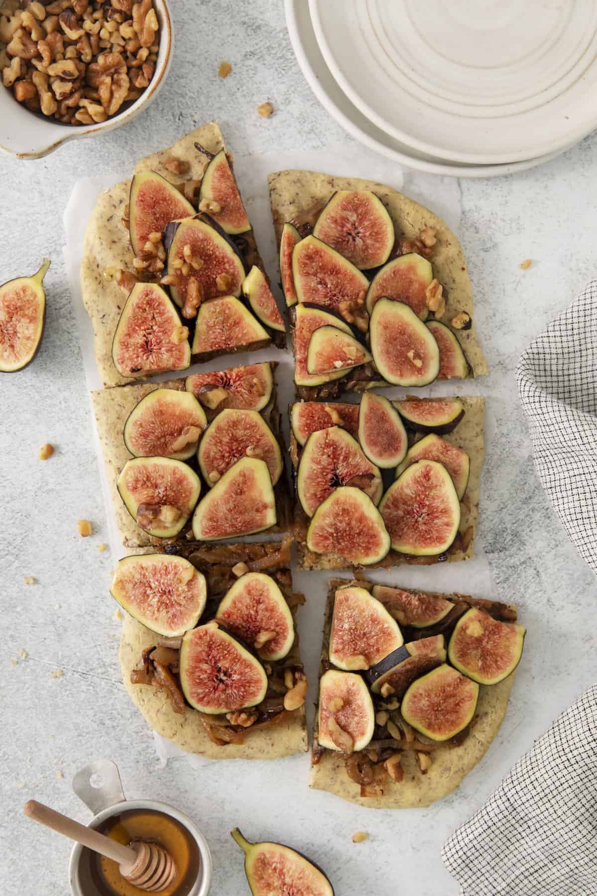 a whole gluten free pizza with figs cut into squares.