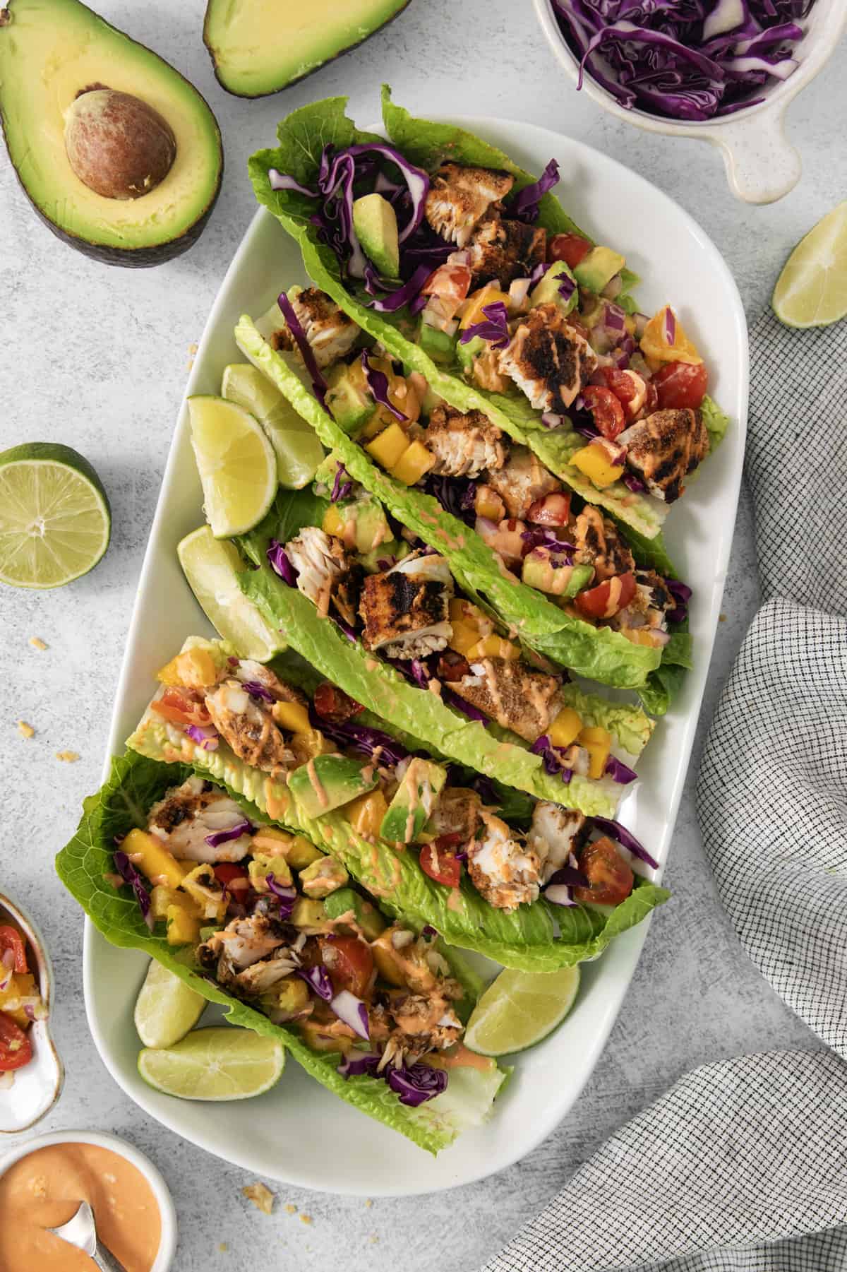 a platter lined with mahi mahi fish tacos in lettuce wraps.