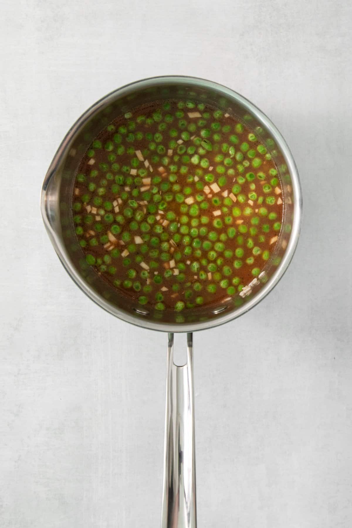 peas added to a pot with broth.