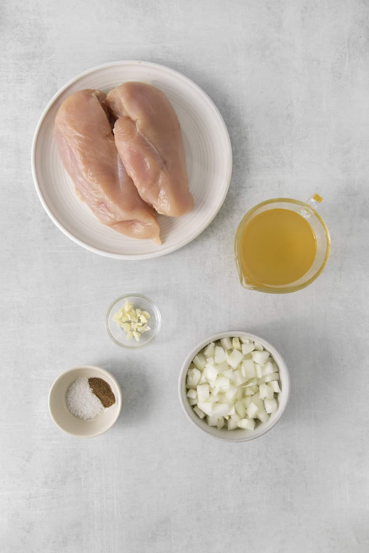 chicken, broth, garlic, onion, and seasonings in separate dishes.