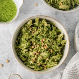 overhead of a bowl of chicken salad next to a small bowl of pesto.