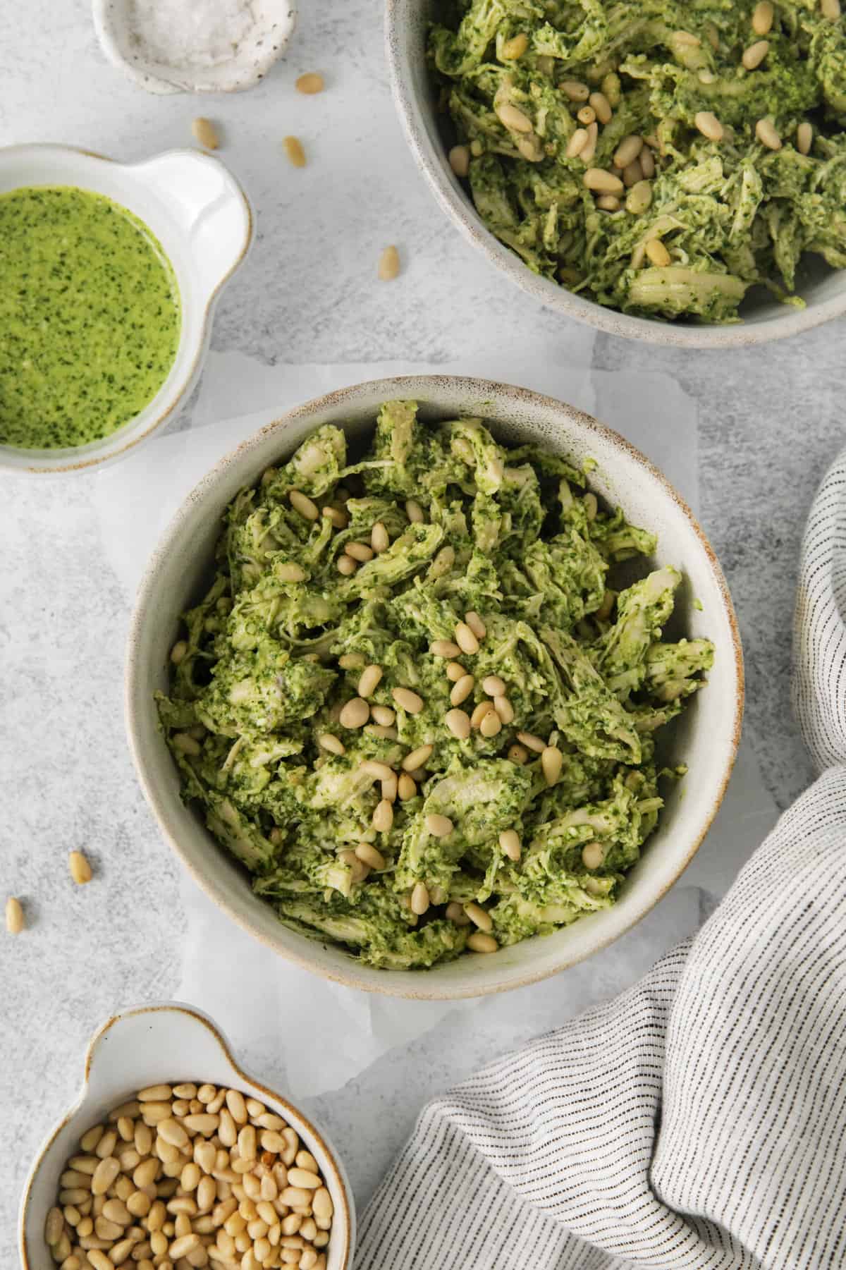 overhead of a bowl of chicken salad next to a small bowl of pesto.