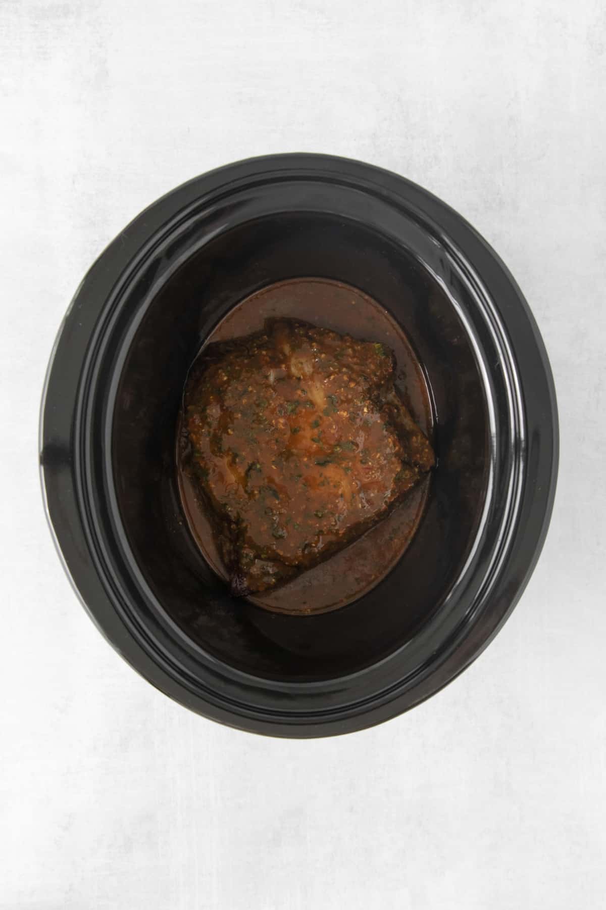 seared steak covered in sauce in a crockpot.