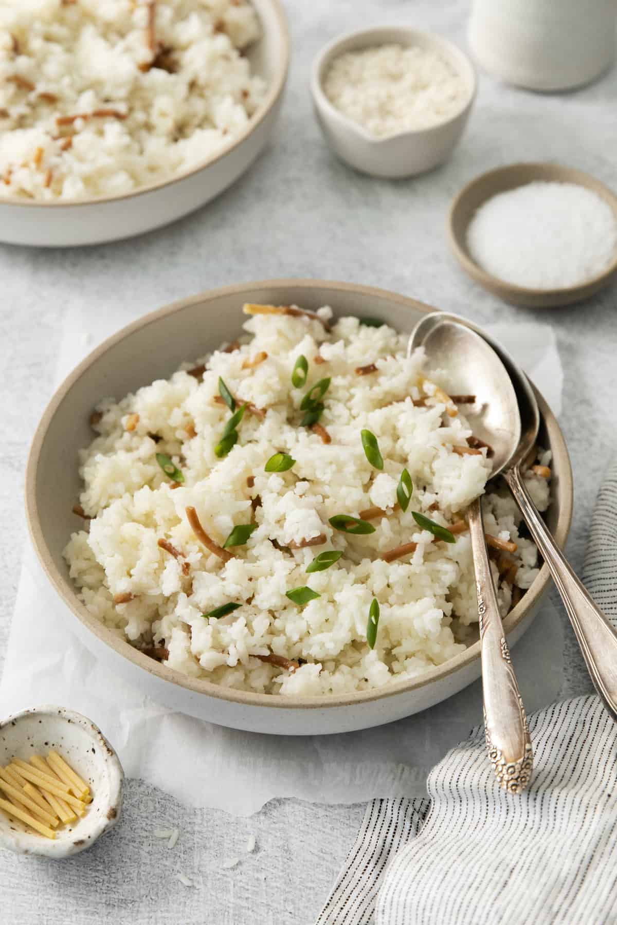 two spoons in a bowl filled with rice pilaf.