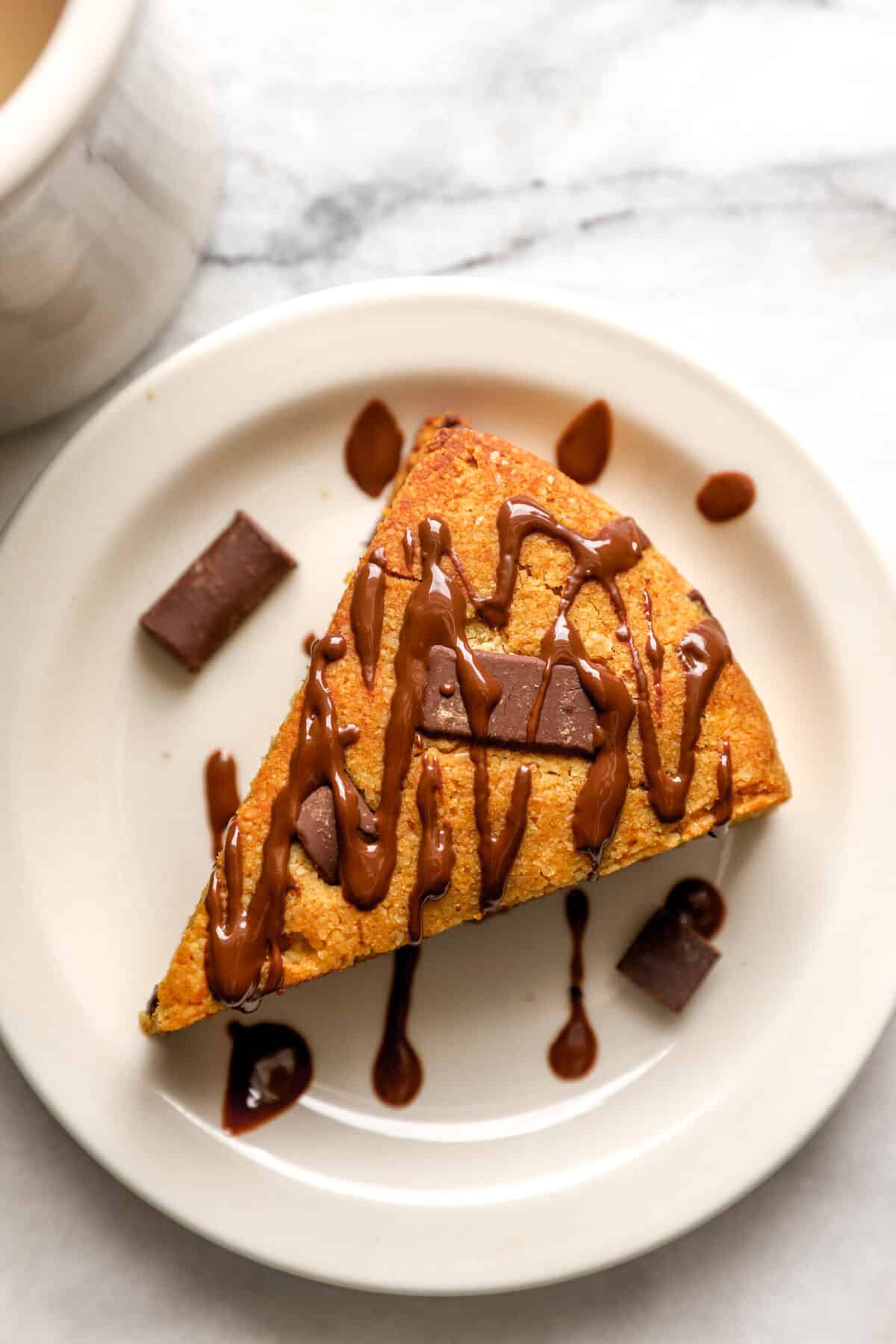 Pumpkin scones on a plate, drizzled with chocolate.