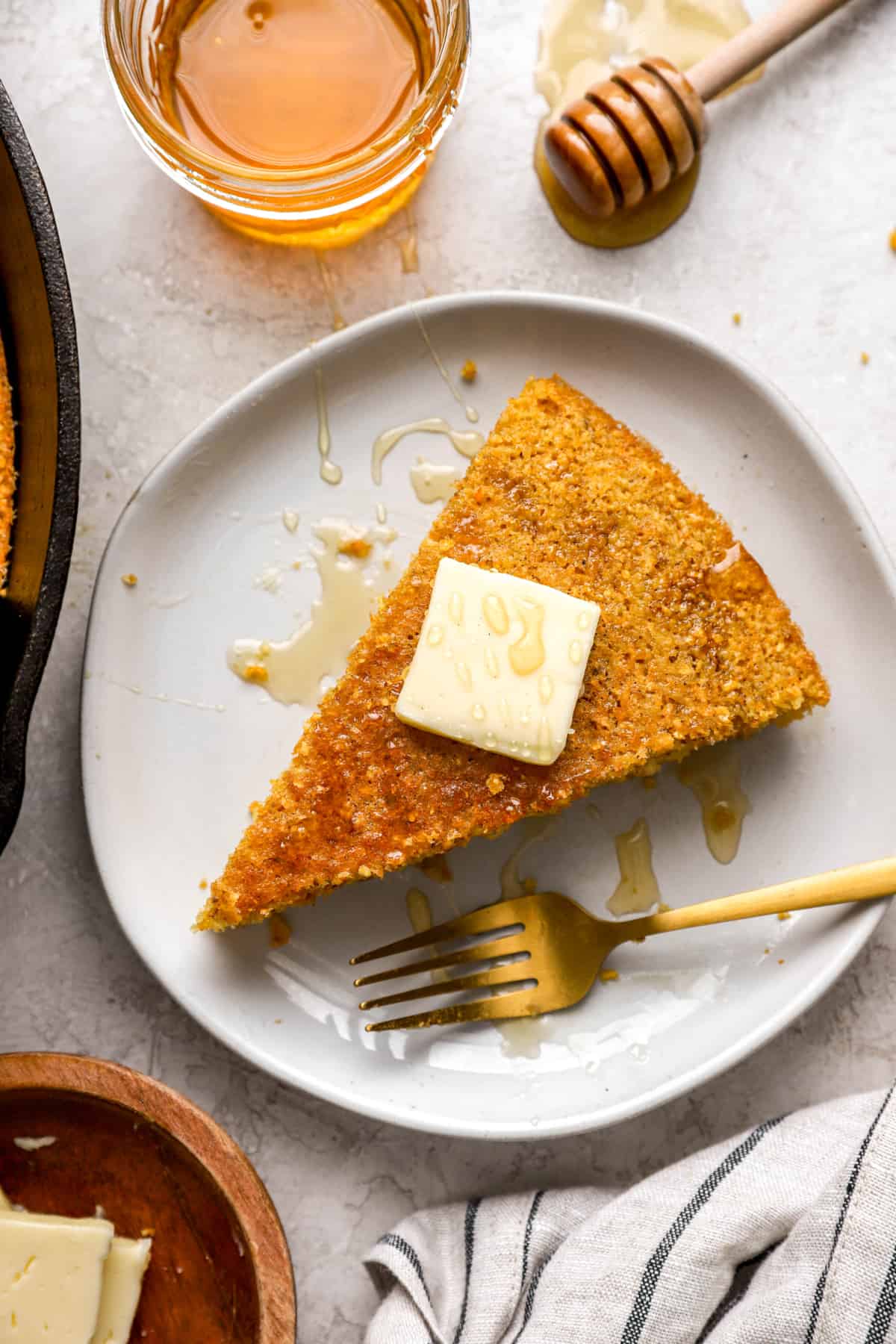 a slice of cornbread from above topped with a piece of butter.