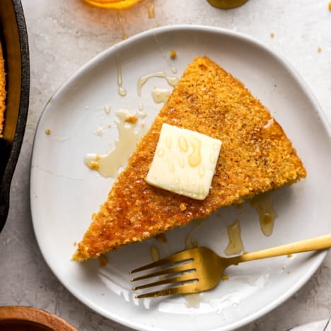 a slice of cornbread from above topped with a piece of butter.