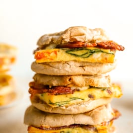 Three assembled breakfast sandwiches stacked on top of each other.