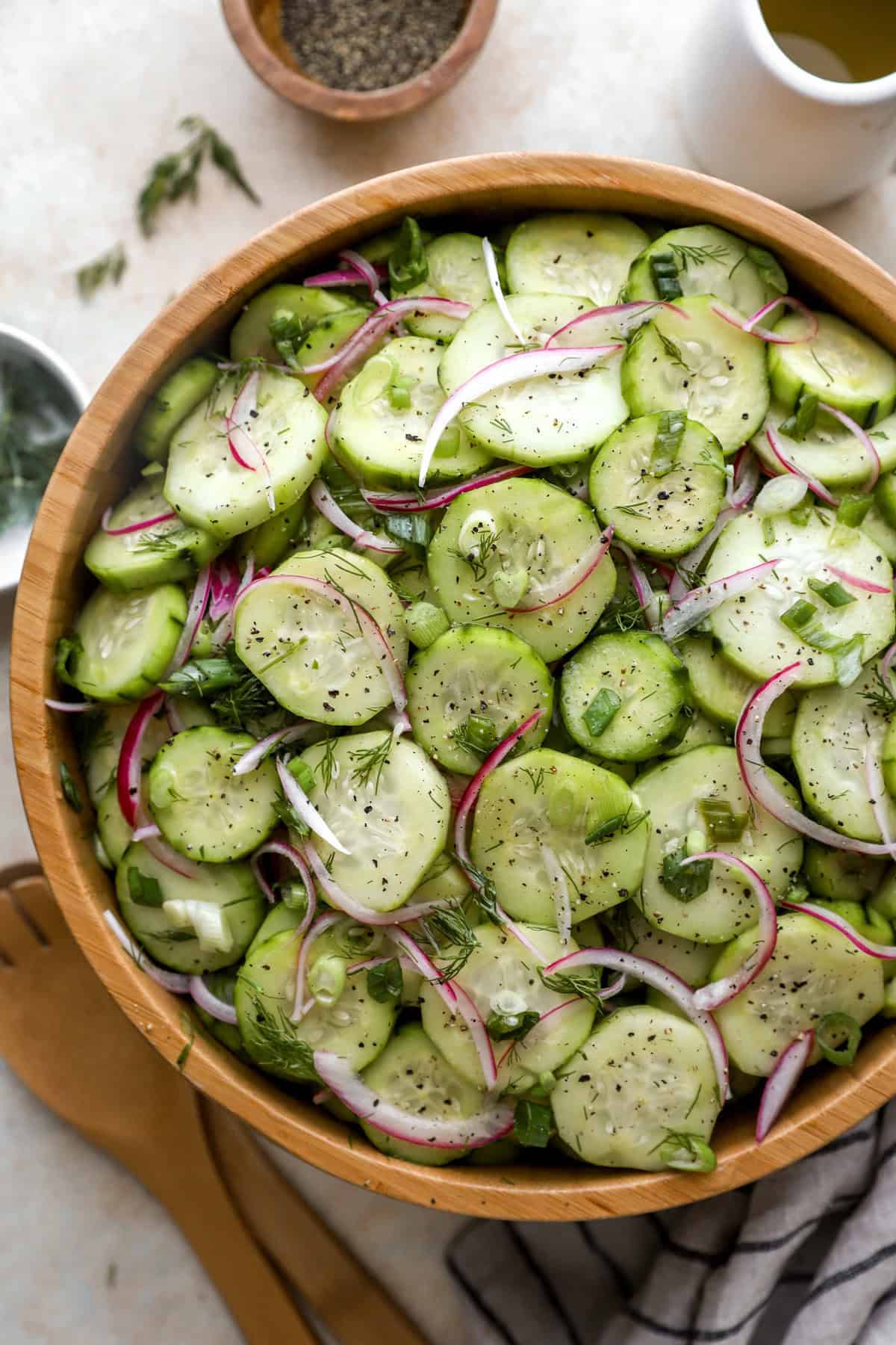 Wooden bowl full of cucumber salad wit red onions. 