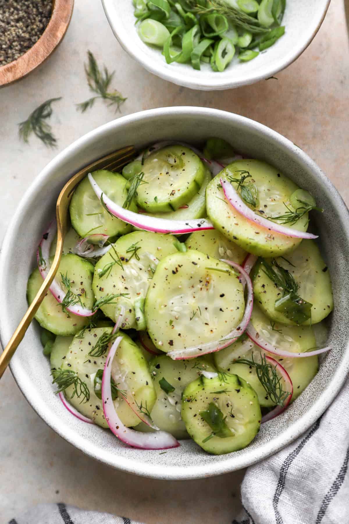A small bowl of sweet cucumber salad with a fork sticking out. 
