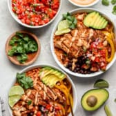 Plated bowls of Copycat Chipotle Chicken Burrito Bowls